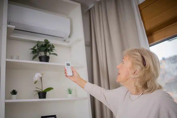 Woman adjusting ductless HVAC system in Franklin Lakes, NJ.